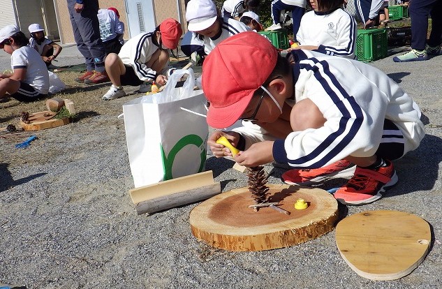 家族で集めてきた松ぼっくりを固定するお子さん