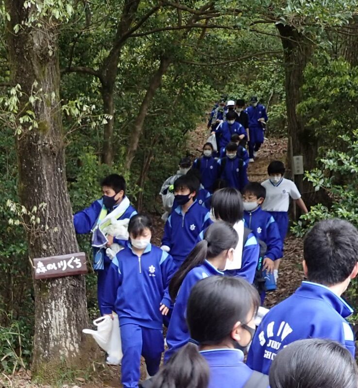 森の入り口で挨拶する中学生