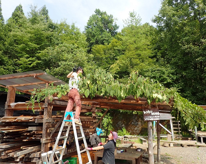 木工作業所の屋根に枝葉を積み上げました