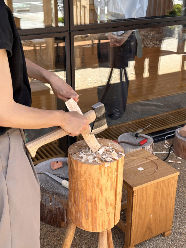 生木を斧で削ってスプーンの形を削り出していく作業