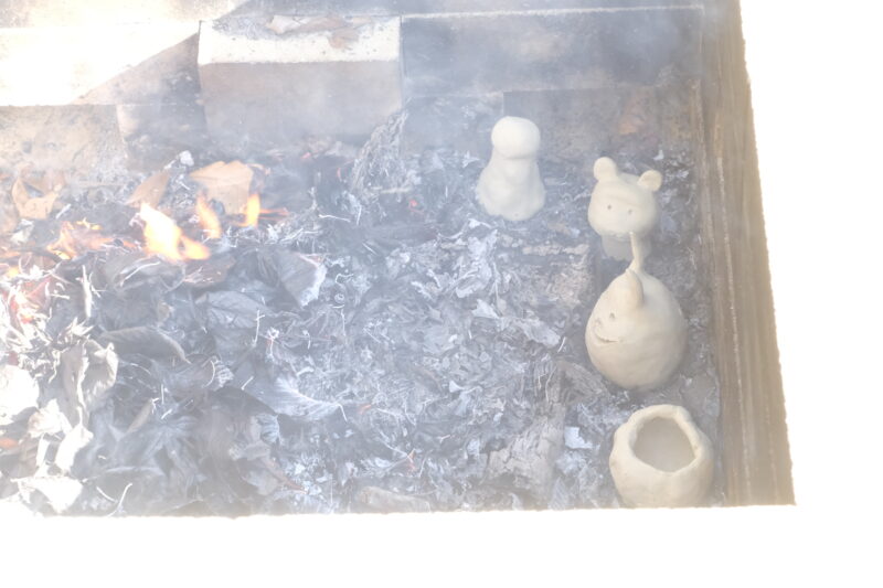 簡易な野焼き窯で1日かけて焼成します