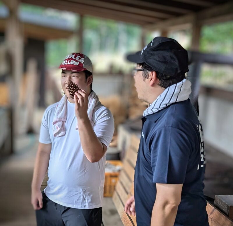 自力建設「みさきの茶屋」で大きな松ぼっくりを手に記念撮影する生徒さん