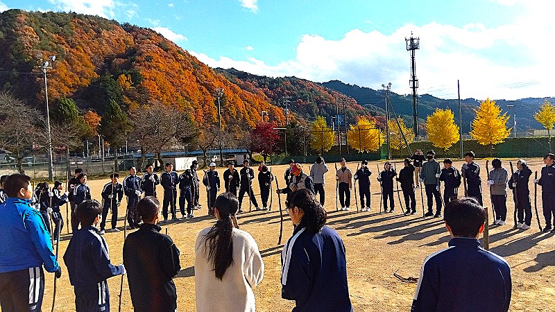 全校生徒で大きなサークルになってスティック・ゲームに挑戦