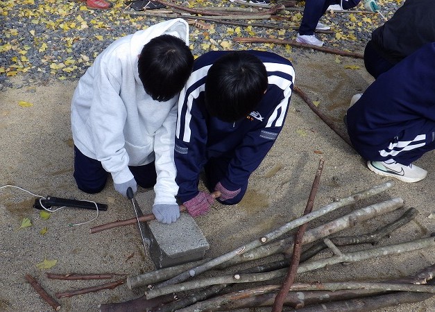 焚き火台に合わせてスティックを切る生徒さん