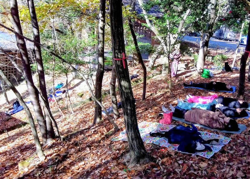 森に寝転んで証さんの演奏淘汰を聞く参加者