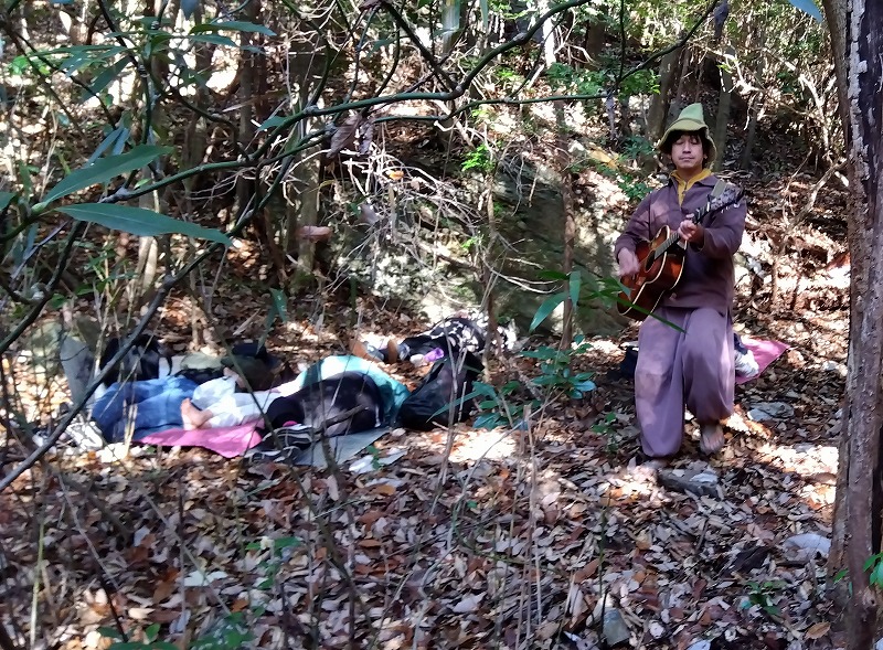 寝転んだ参加者の間を歌いながら回る証さん