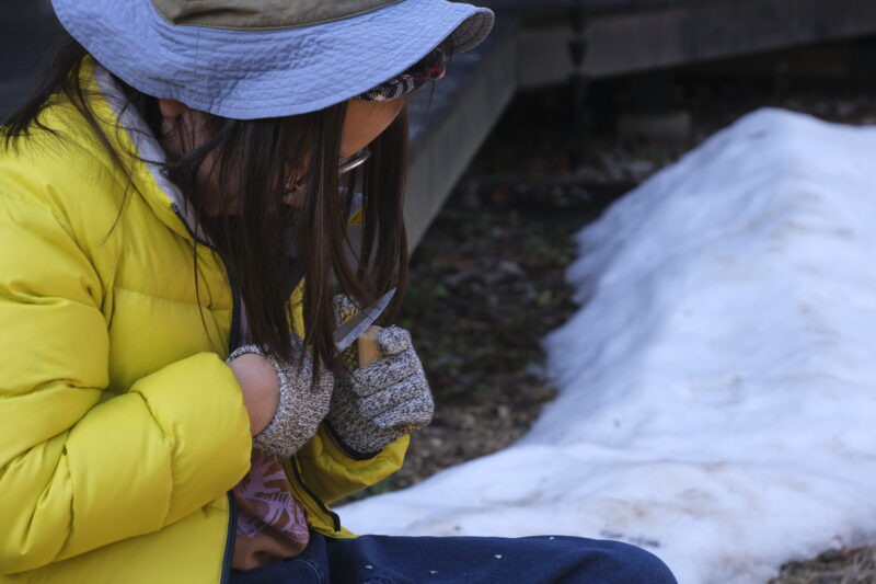 雪の残るコテージ中庭でナイフワーク
