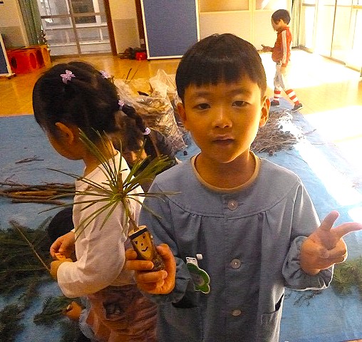 コウヤマキで飾った作品を持つ園児さん